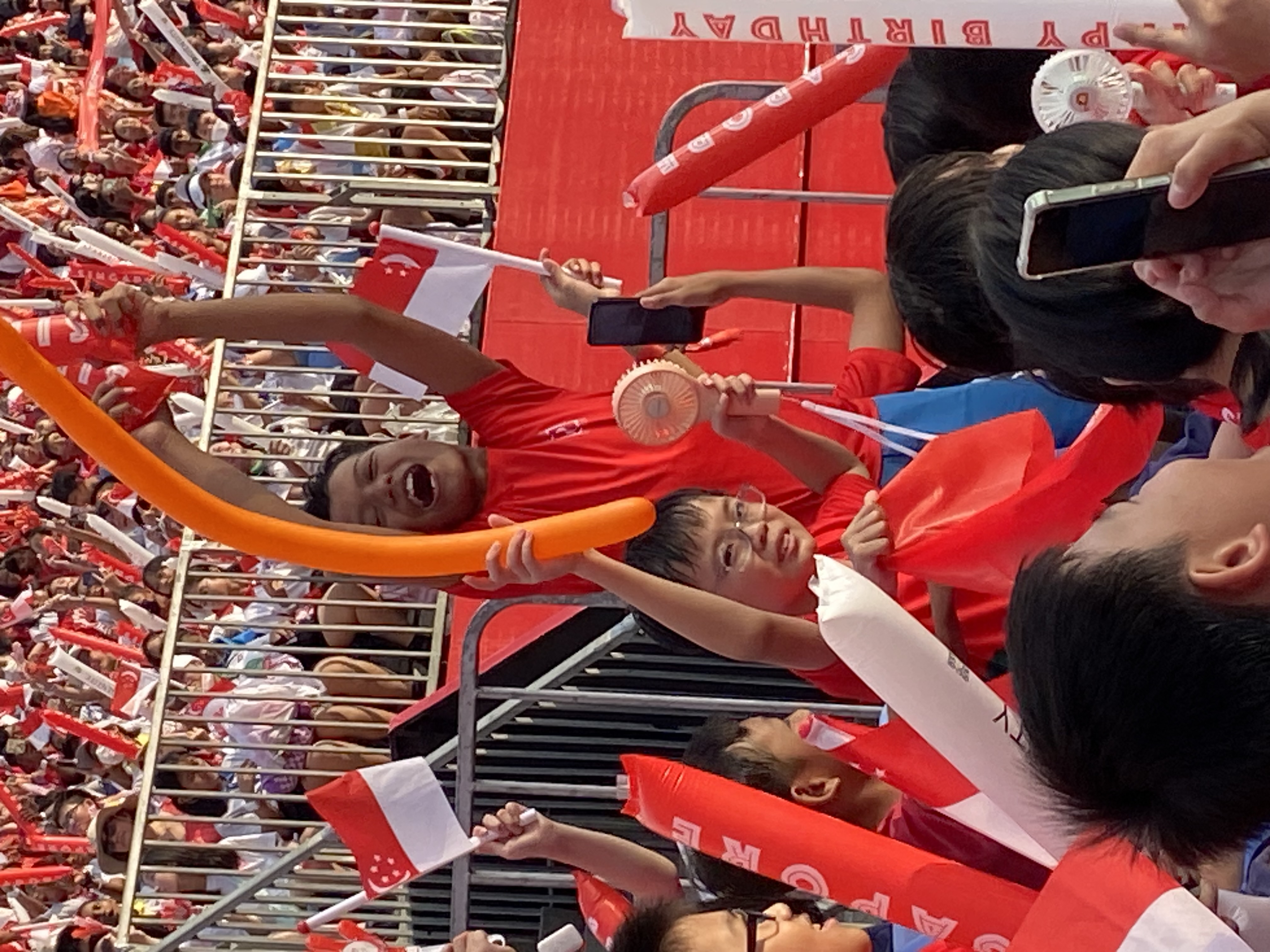 A student at NE show standing up to celebrate