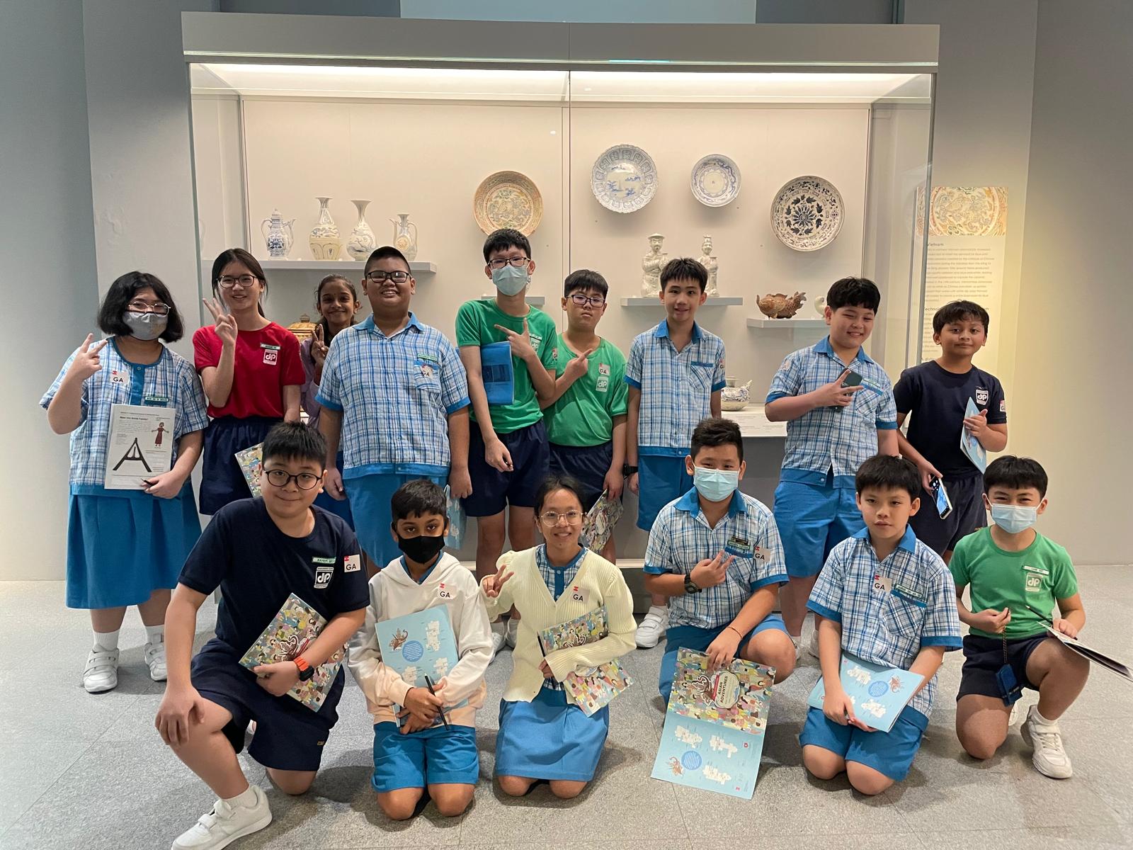 A group of students posing with ACM exhibits as background.