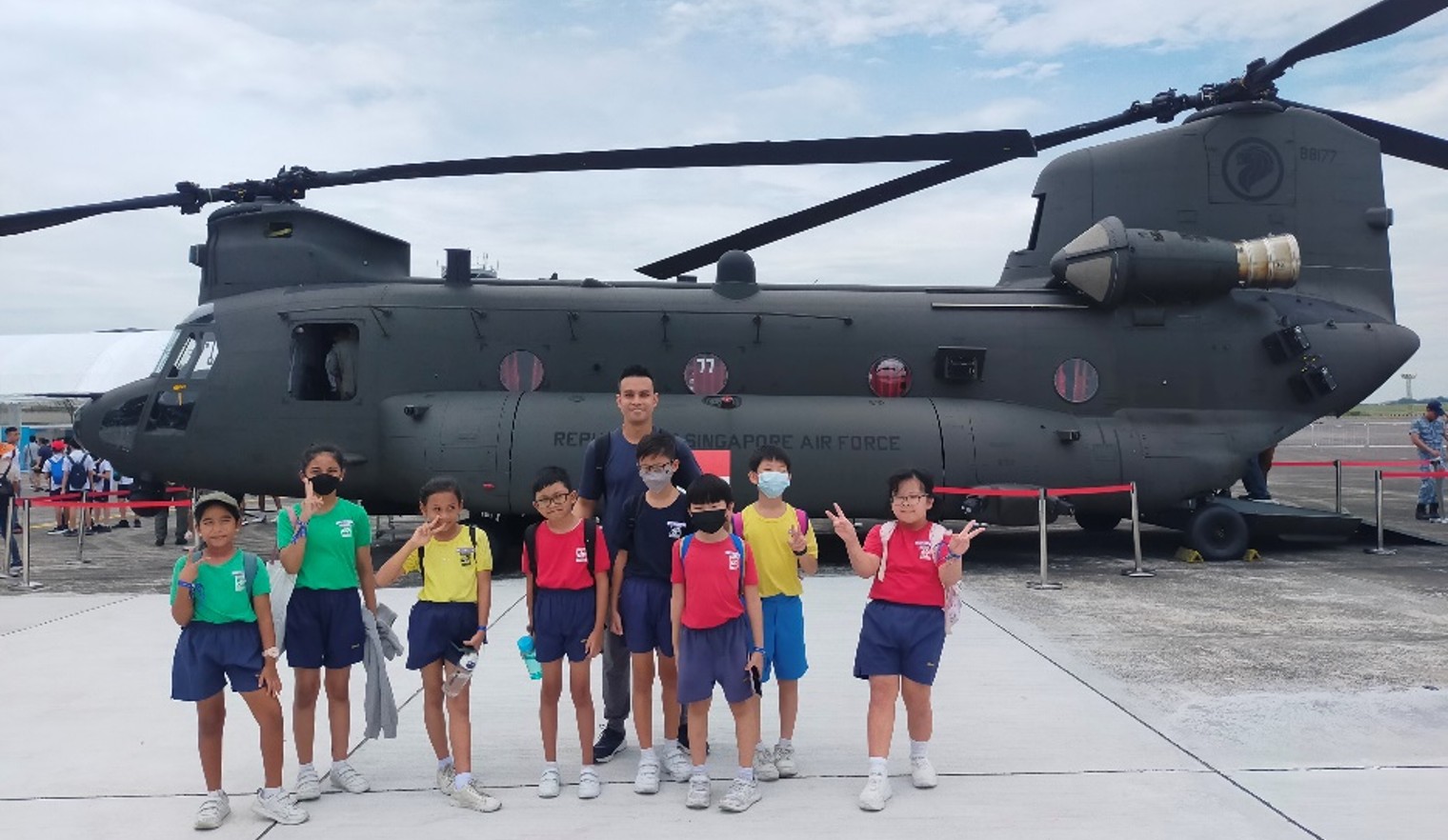 NE ambassadors taking photo with a Chinook at RSAF open house