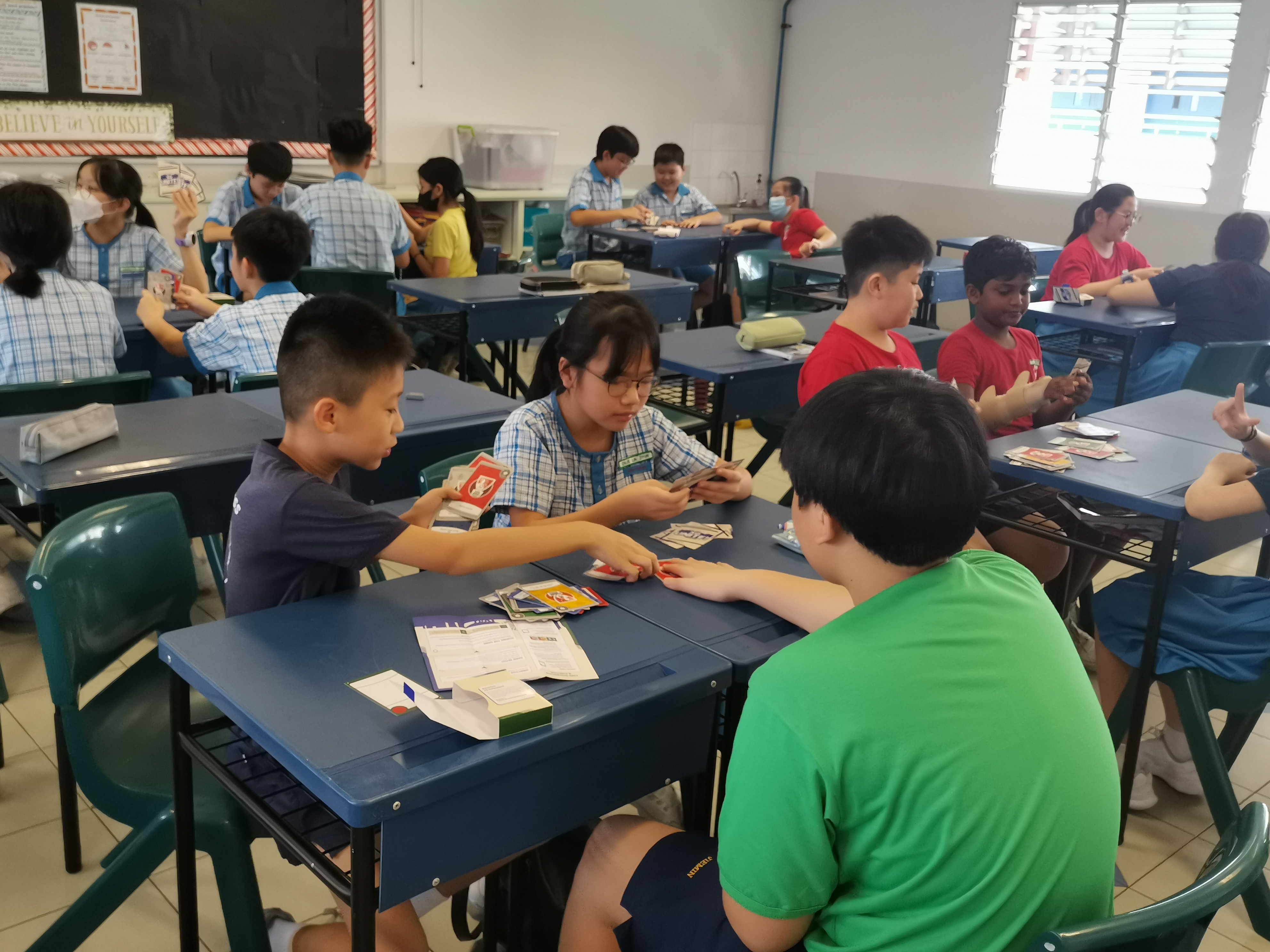 A group of students playing with Total Defence card.