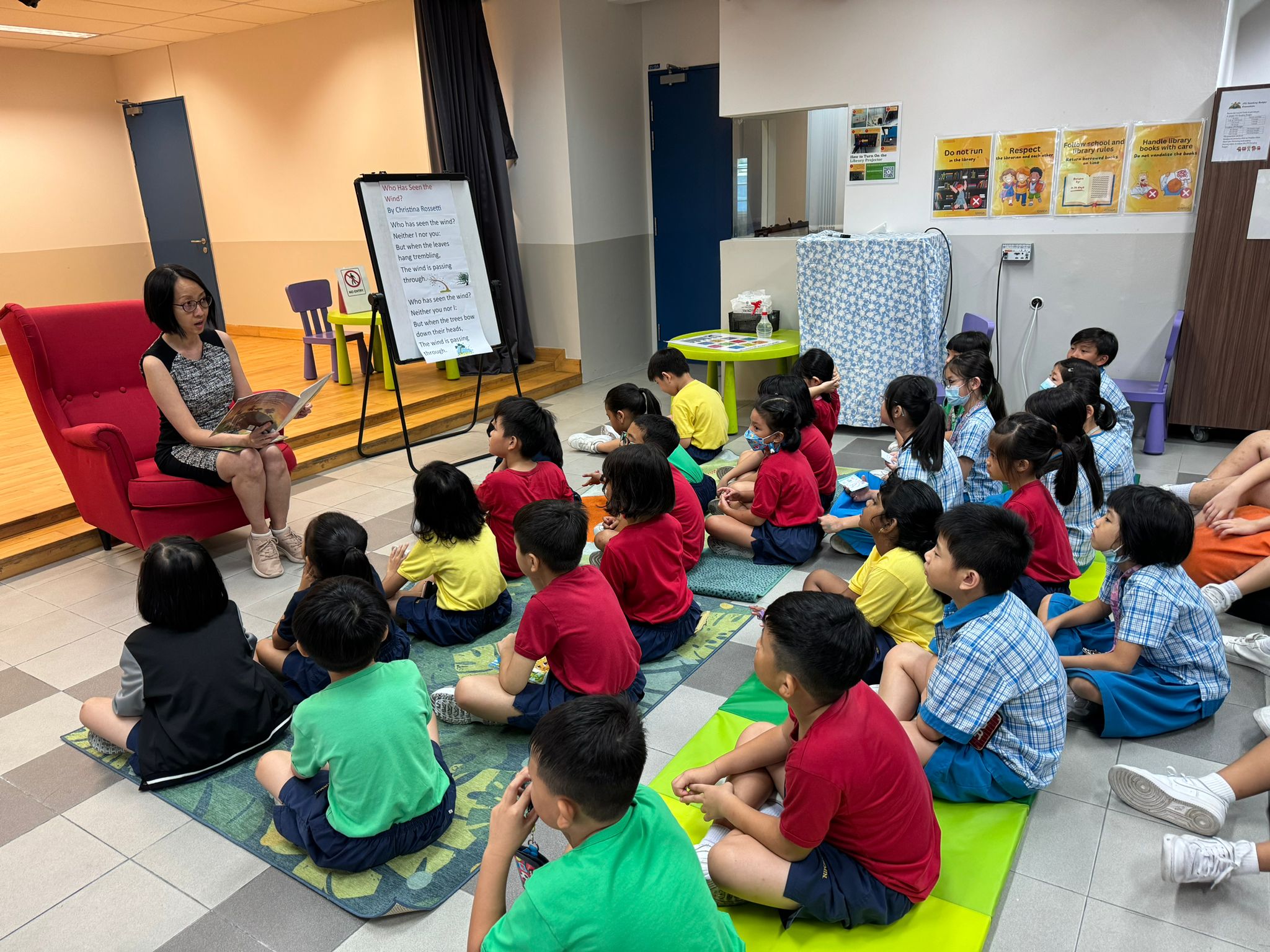 Our VP, Ms Wong, reading to the pupils during recess.